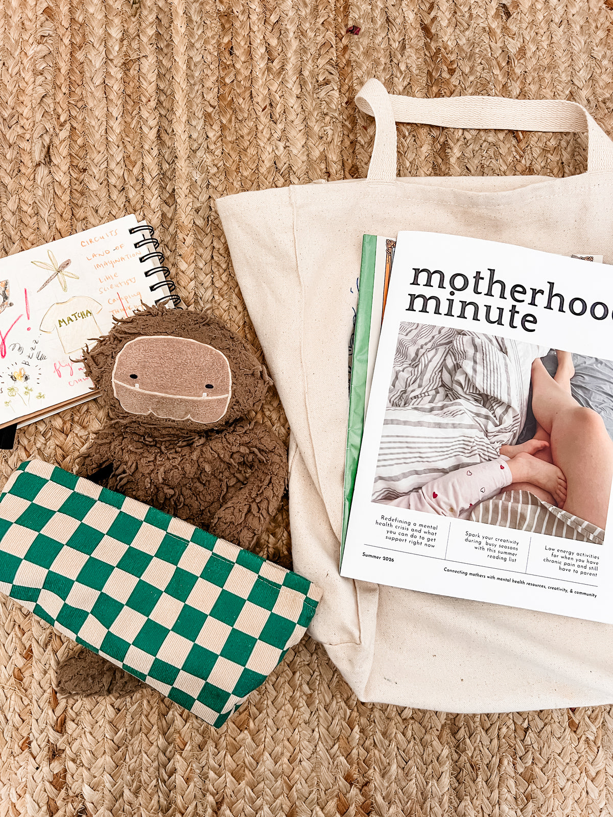 Motherhood Minute Magazine with a toy and bag.
